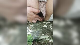 Masturbating on the tree using dry twig. Hairy cunt in the forest