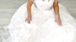 Backstage of a whore bride posing in a photo studio after her wedding with a vibrator